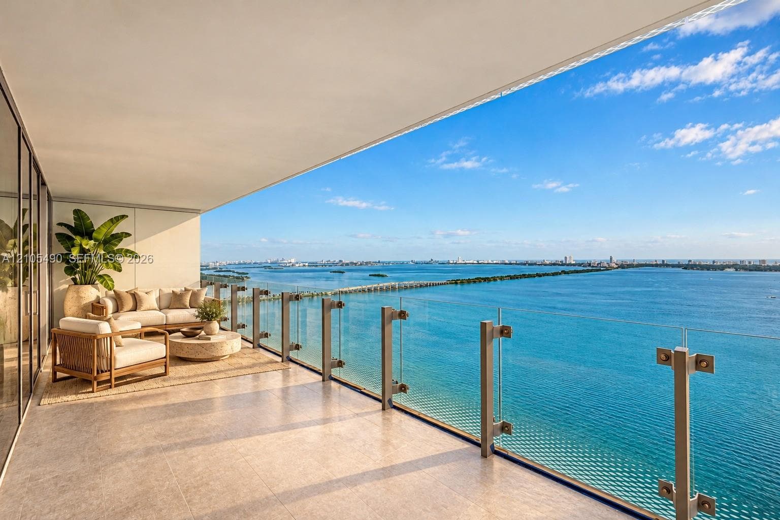 Expansive covered balcony featuring large-format stone tile flooring and a minimalist glass railing system with metal hardware