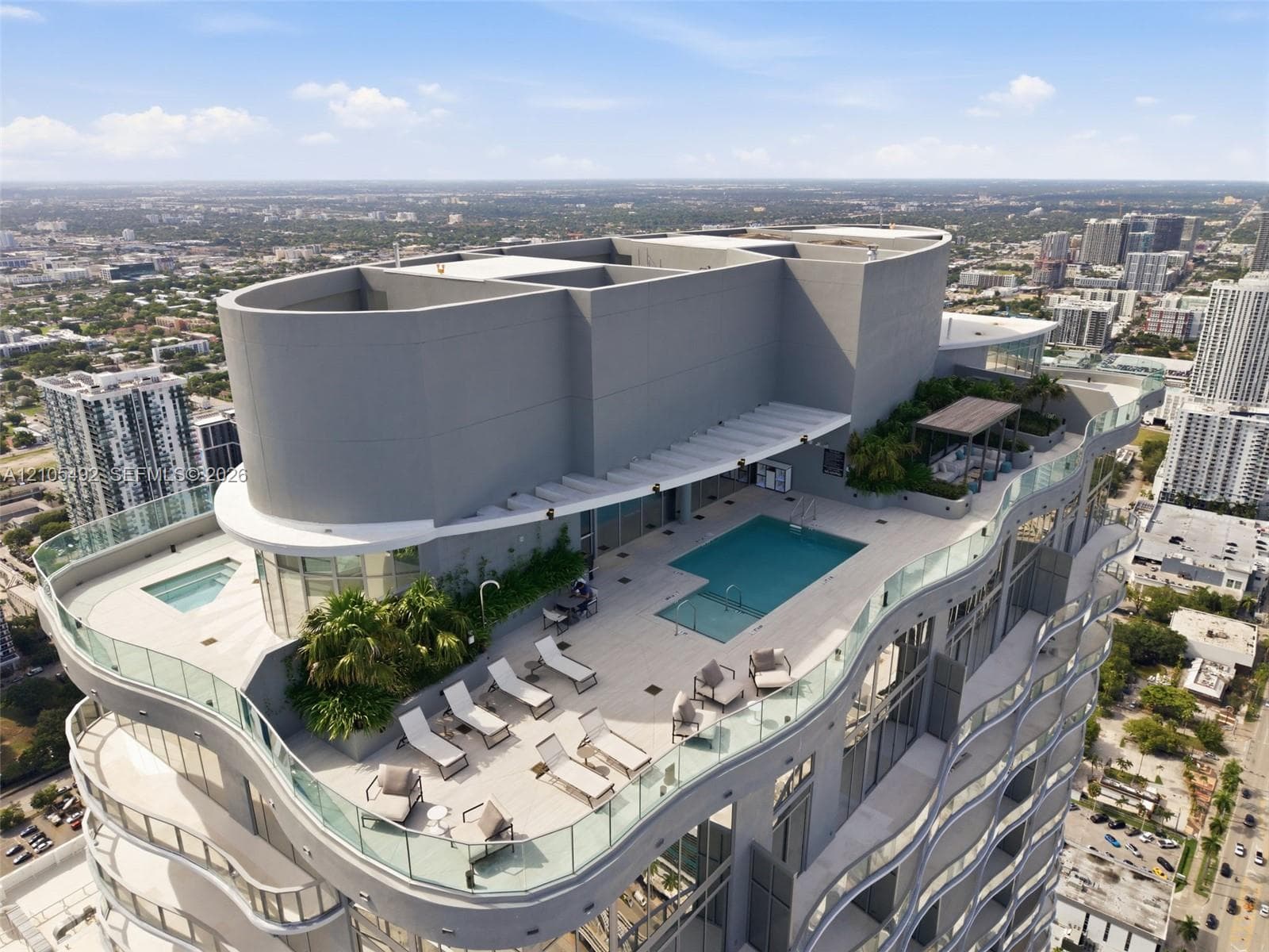 Rooftop terrace featuring a swimming pool, spa, glass perimeter railings, and integrated landscaping