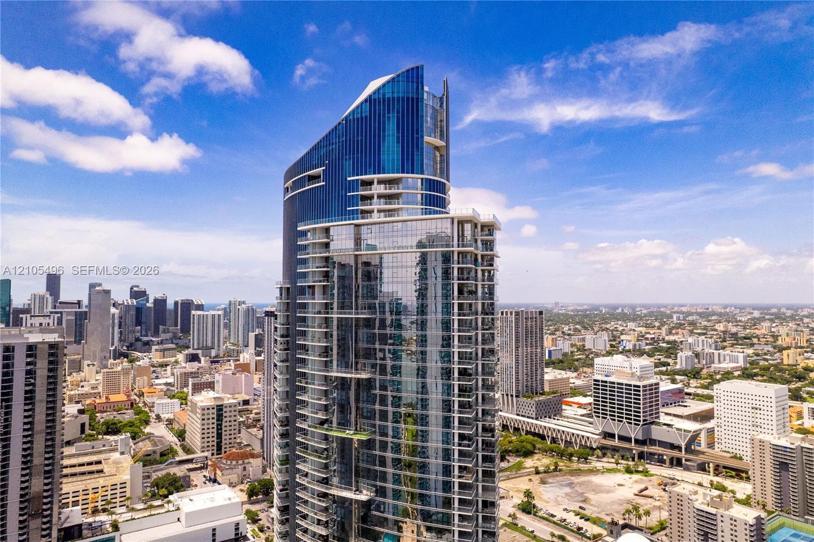 High-rise residential tower featuring a glass-curtain wall facade, staggered private balconies, and an angular architectural profile