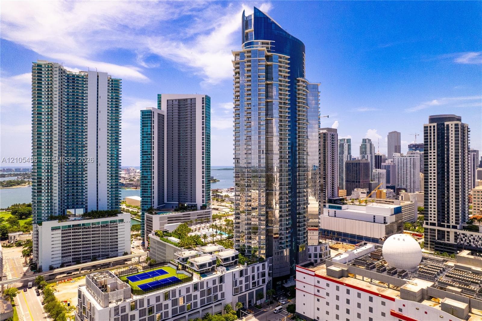 High-rise architectural structure featuring a glass-curtain wall facade, expansive balcony tiers, and integrated rooftop recreation space