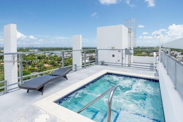 Rooftop terrace featuring a built-in spa with blue and white tile accents, and a stainless steel handrail
