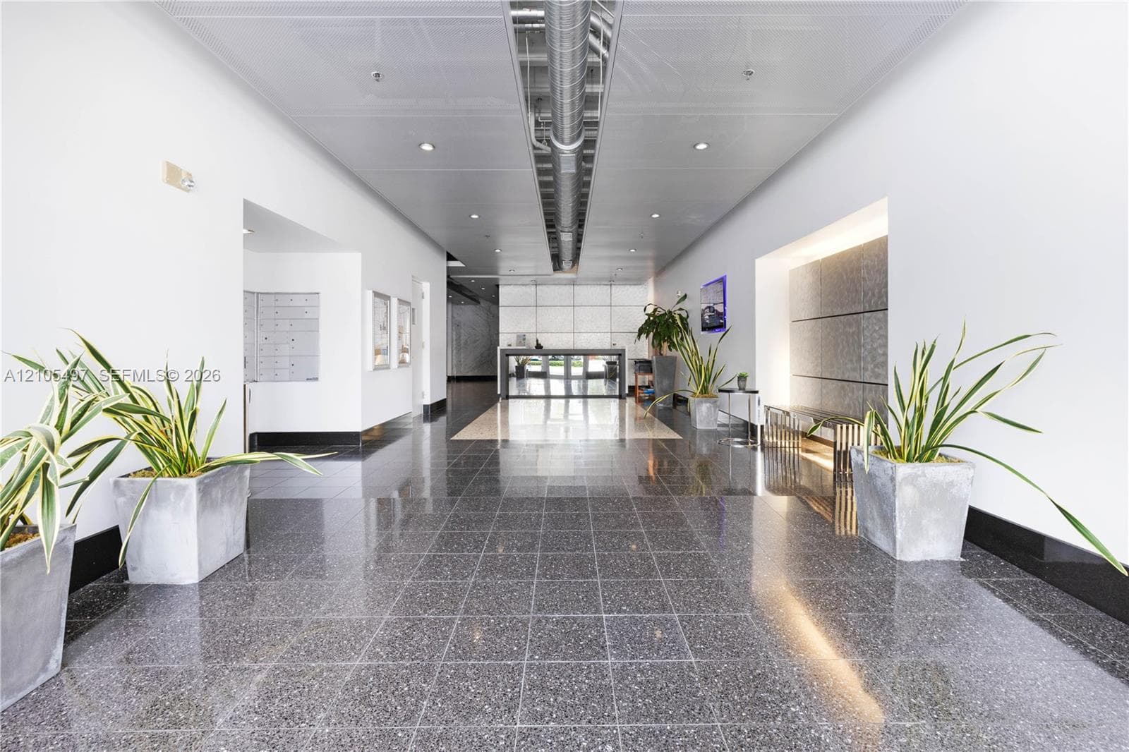 Polished terrazzo flooring, white walls, exposed ceiling ductwork, recessed lighting, and wall-mounted mailboxes