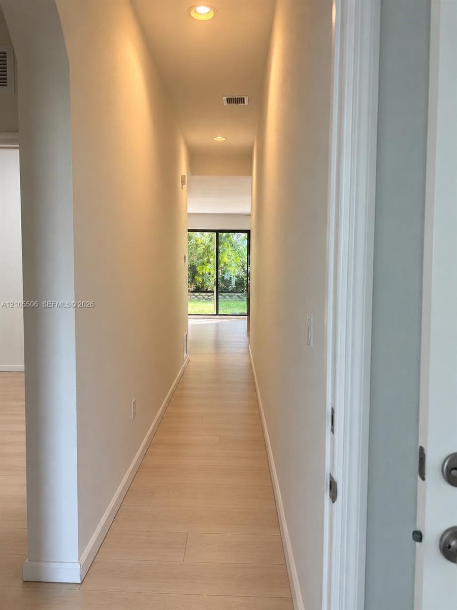 Hallway featuring recessed lighting, light-colored wood-finish flooring, and white baseboards