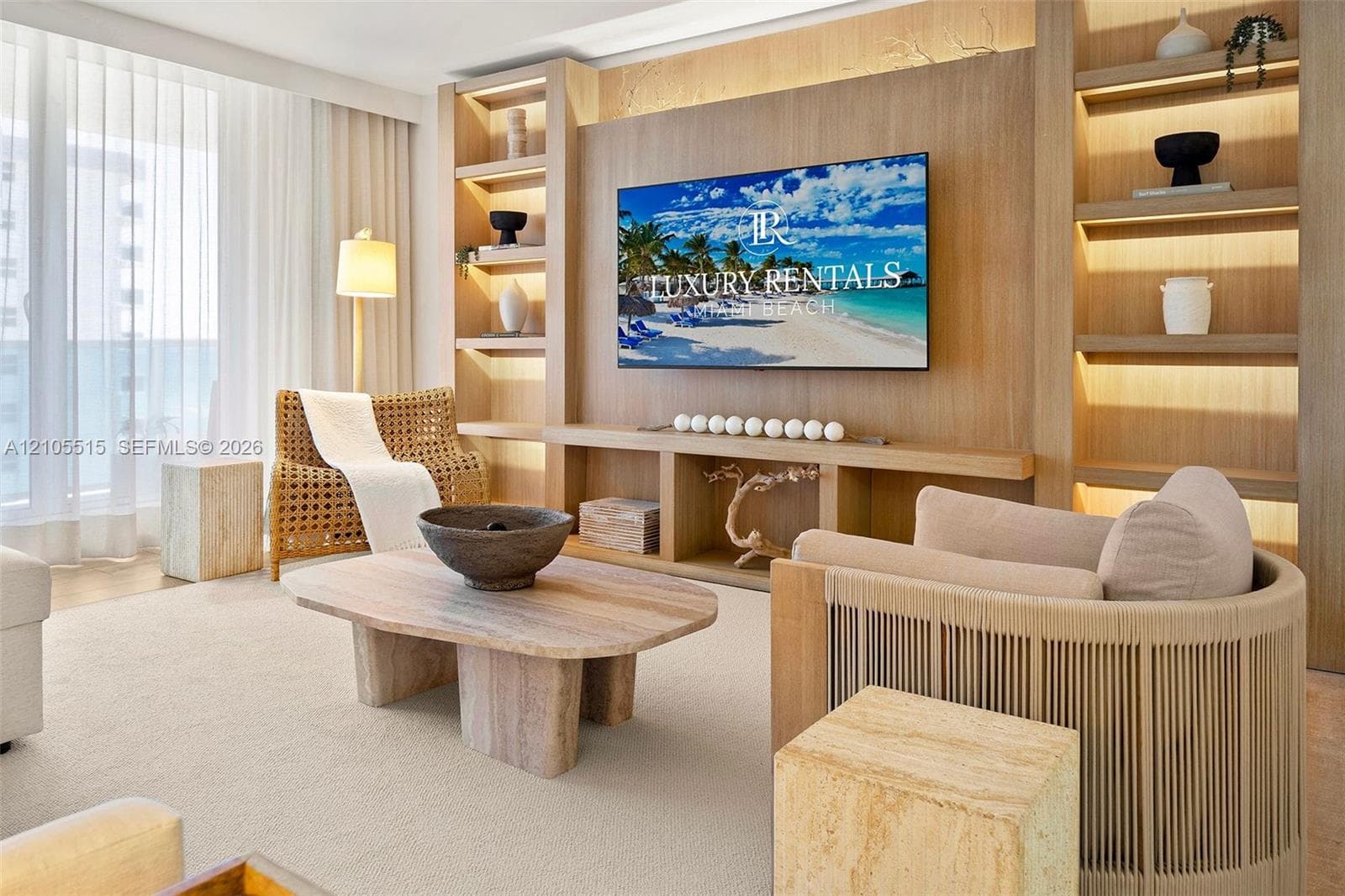 Custom wood-paneled media wall featuring floor-to-ceiling integrated shelving with recessed accent lighting and a floating console