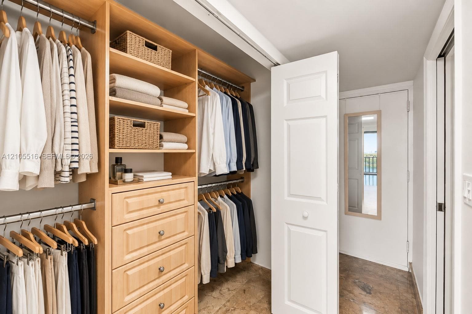 Custom closet system featuring natural wood-finish cabinetry, built-in shelving, and multiple hanging rods