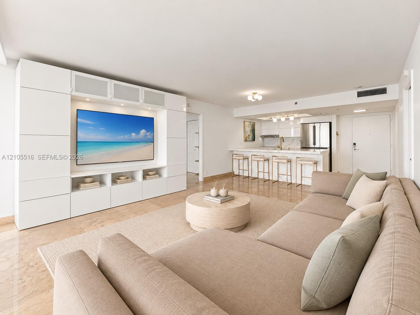 Open-concept living space featuring integrated media cabinetry, recessed lighting, and stone-look flooring
