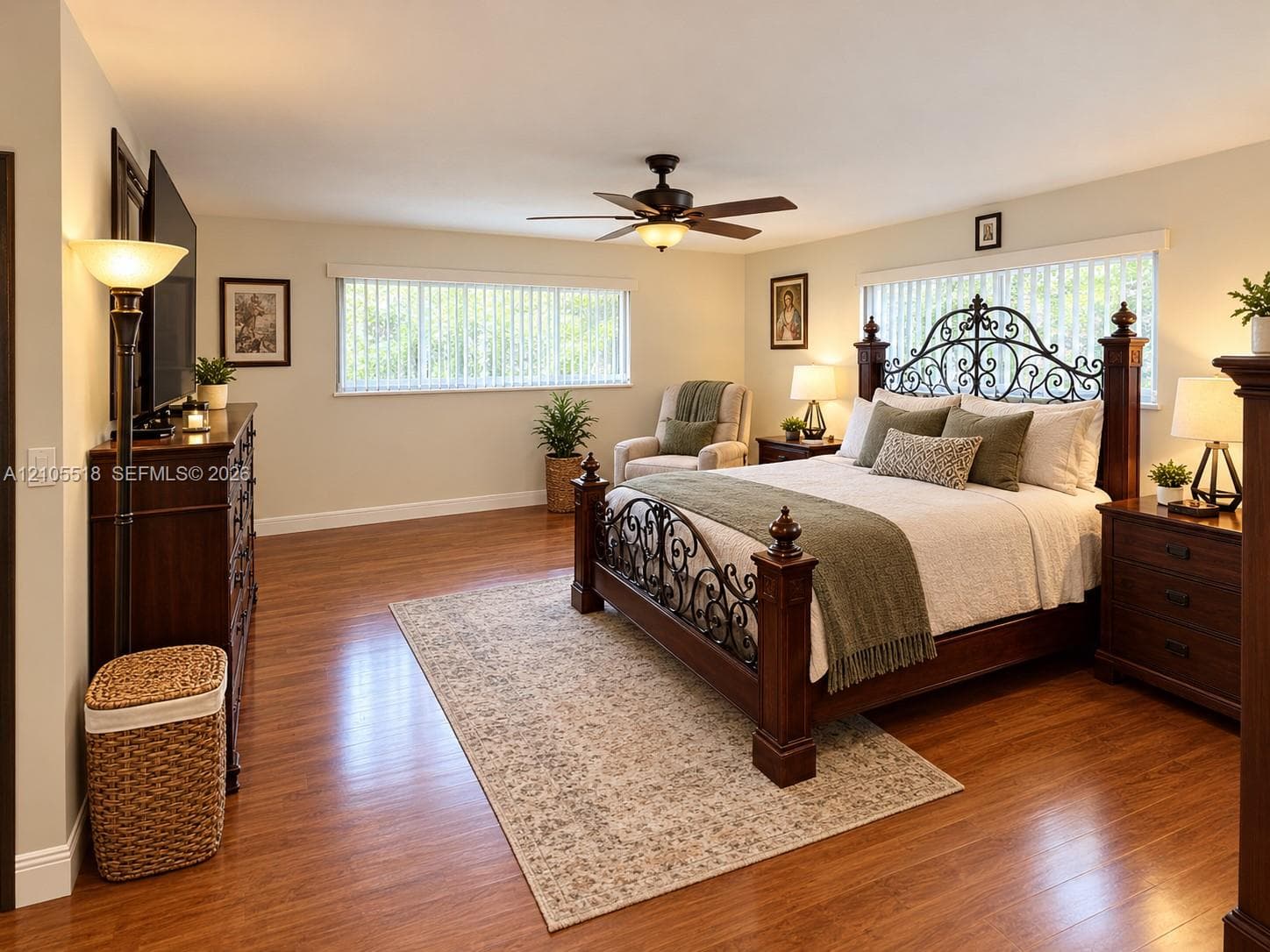 Expansive room featuring wood-finish flooring, horizontal blinds, and an integrated ceiling fan