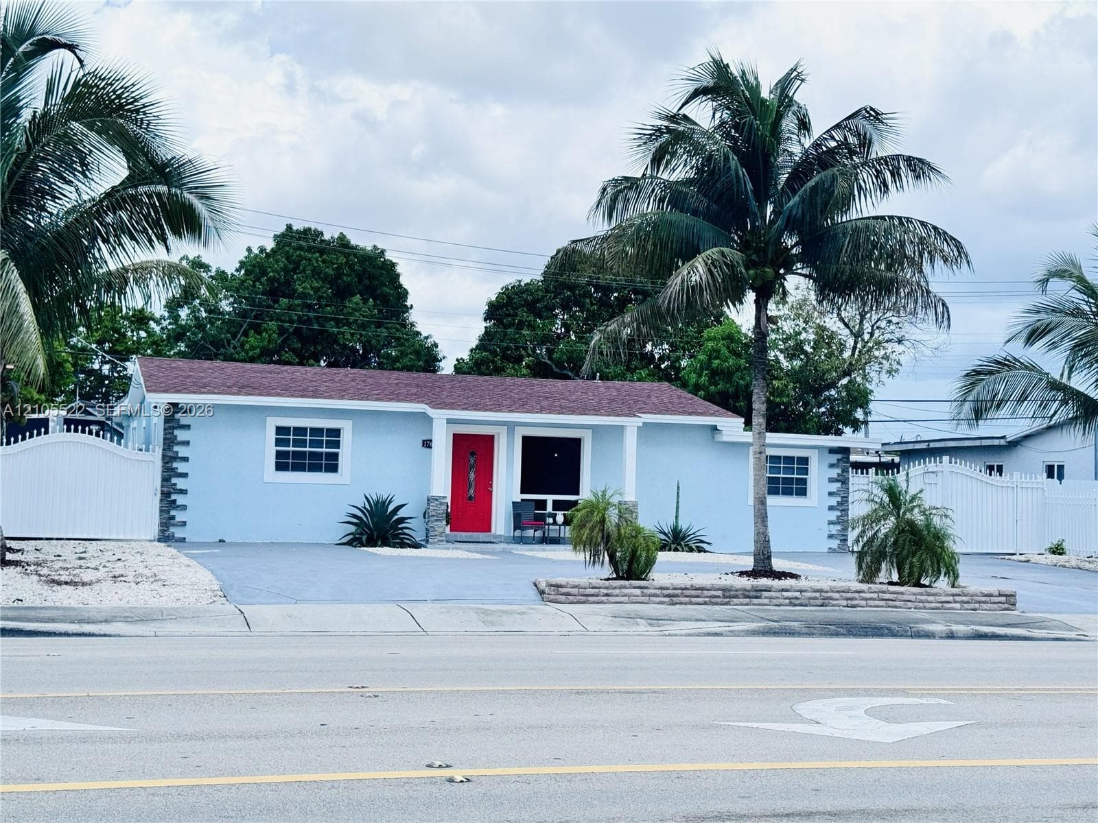 Light blue exterior with white trim windows and a red entry door