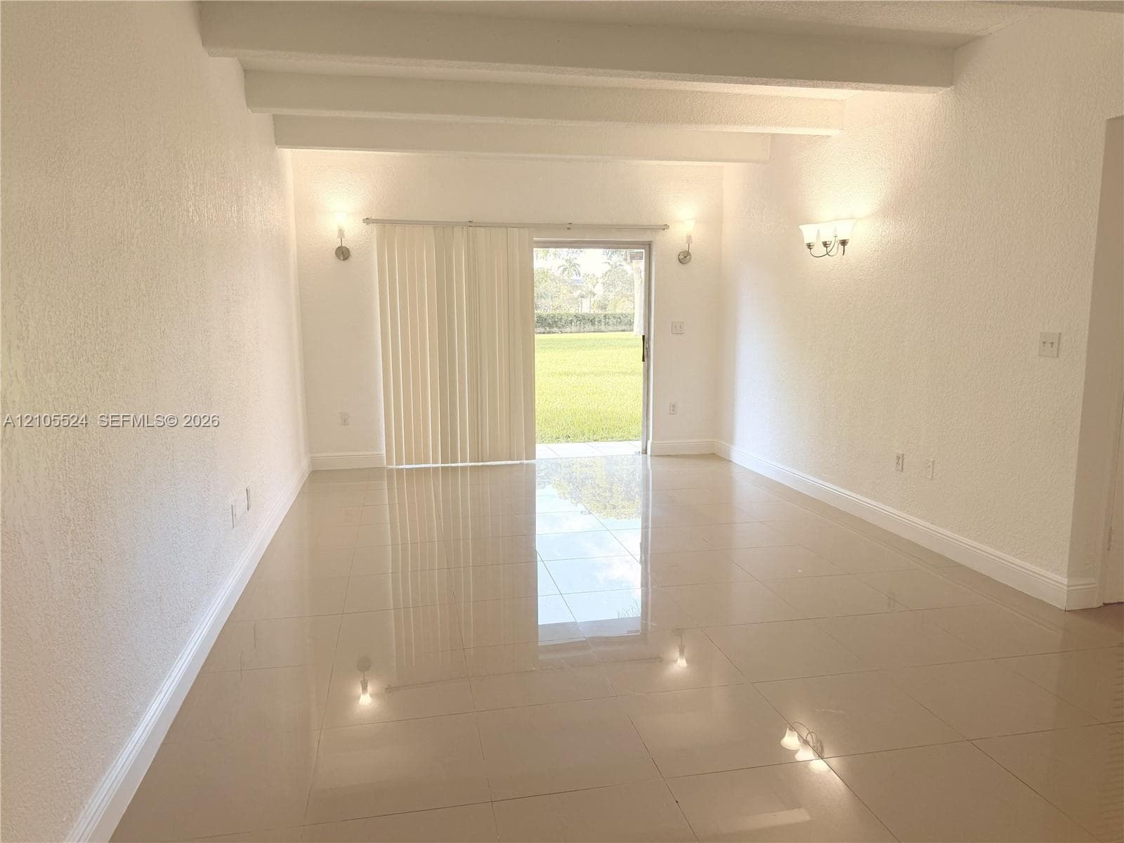 Smooth tile flooring, exposed ceiling beams, and sliding glass doors