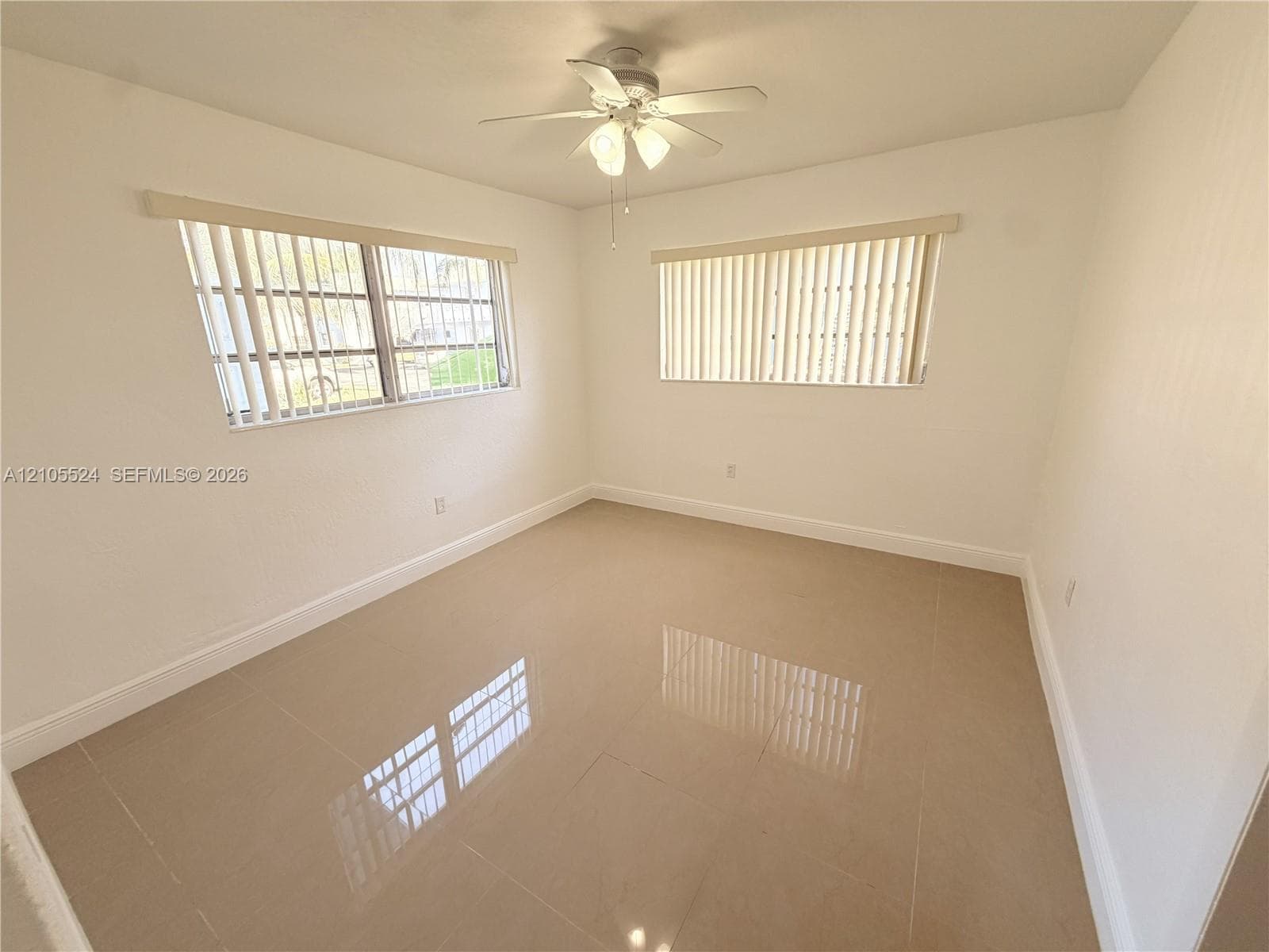 Recessed lighting, ceiling fan, two windows, and tile flooring