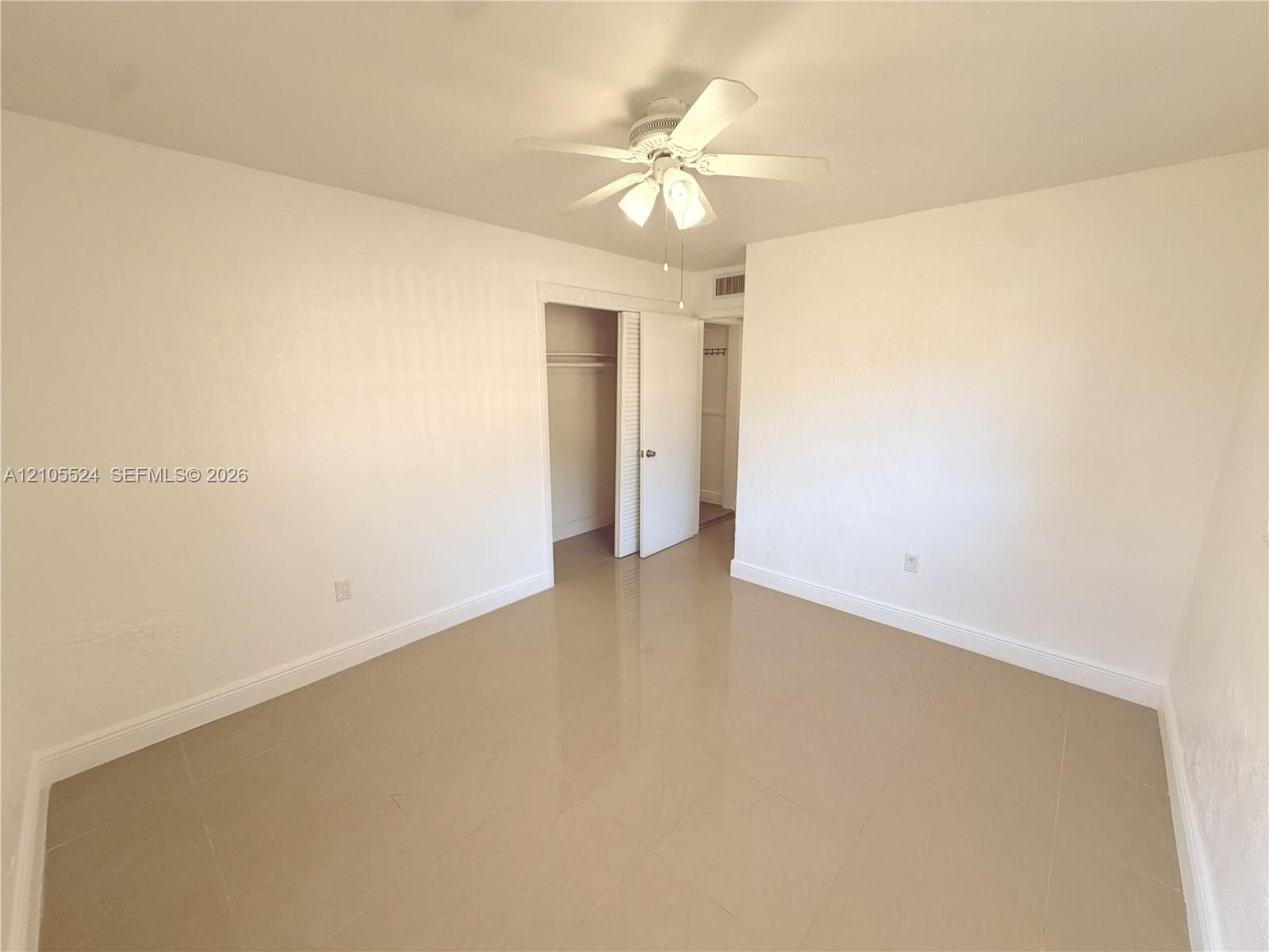 Neutral tone wall finish with recessed lighting and a ceiling fan