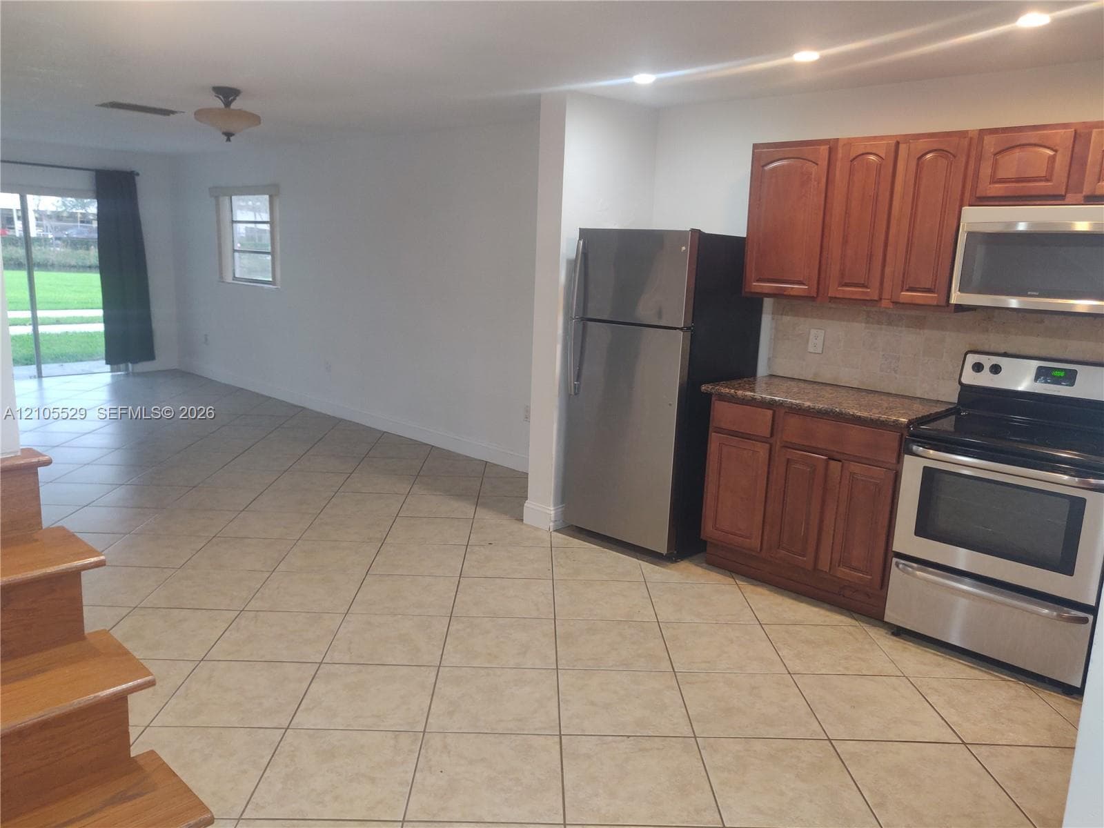 Kitchen featuring wood cabinetry, stainless steel appliances, and stone countertops