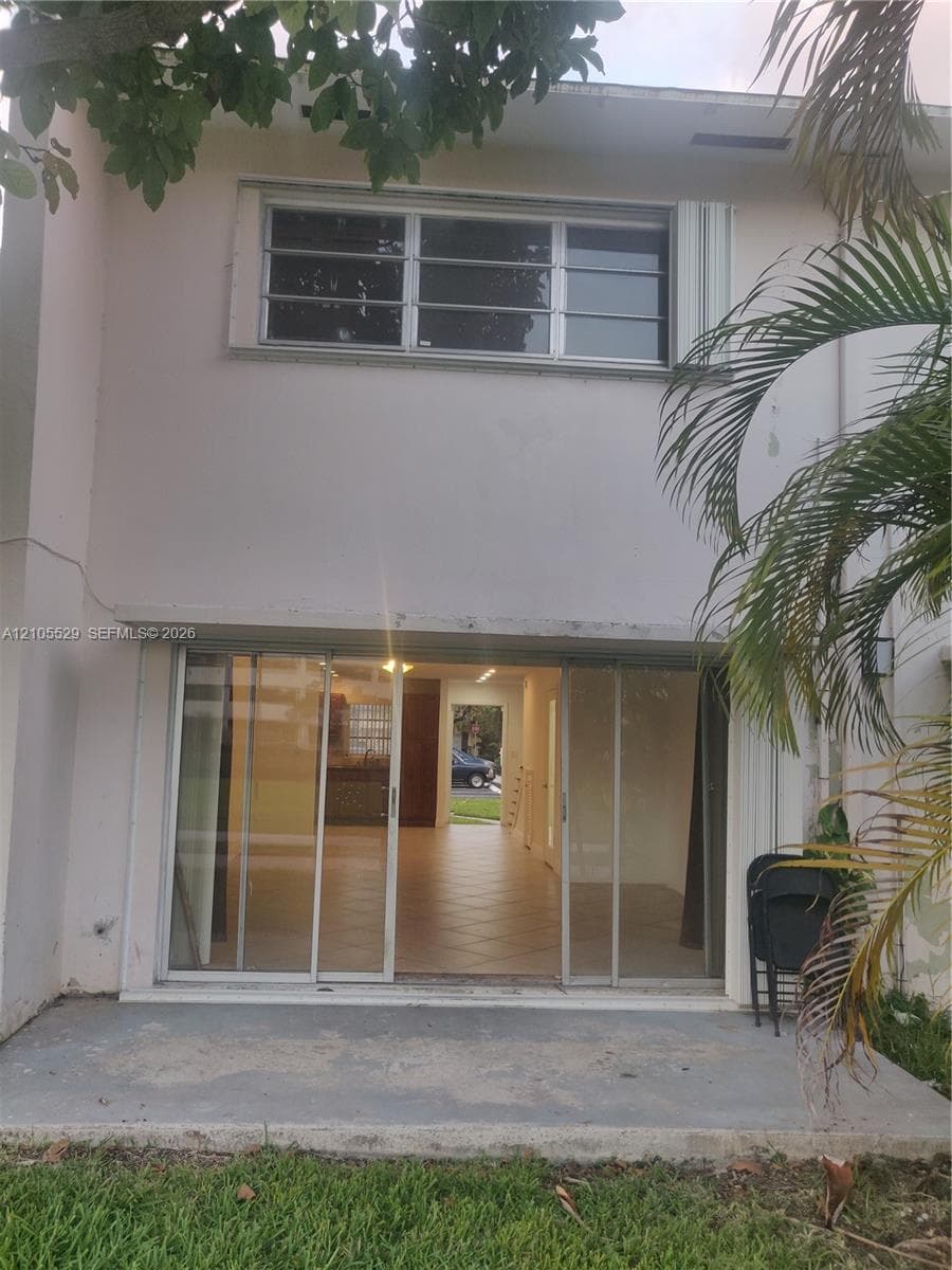 Lower-level sliding glass doors open to a concrete patio