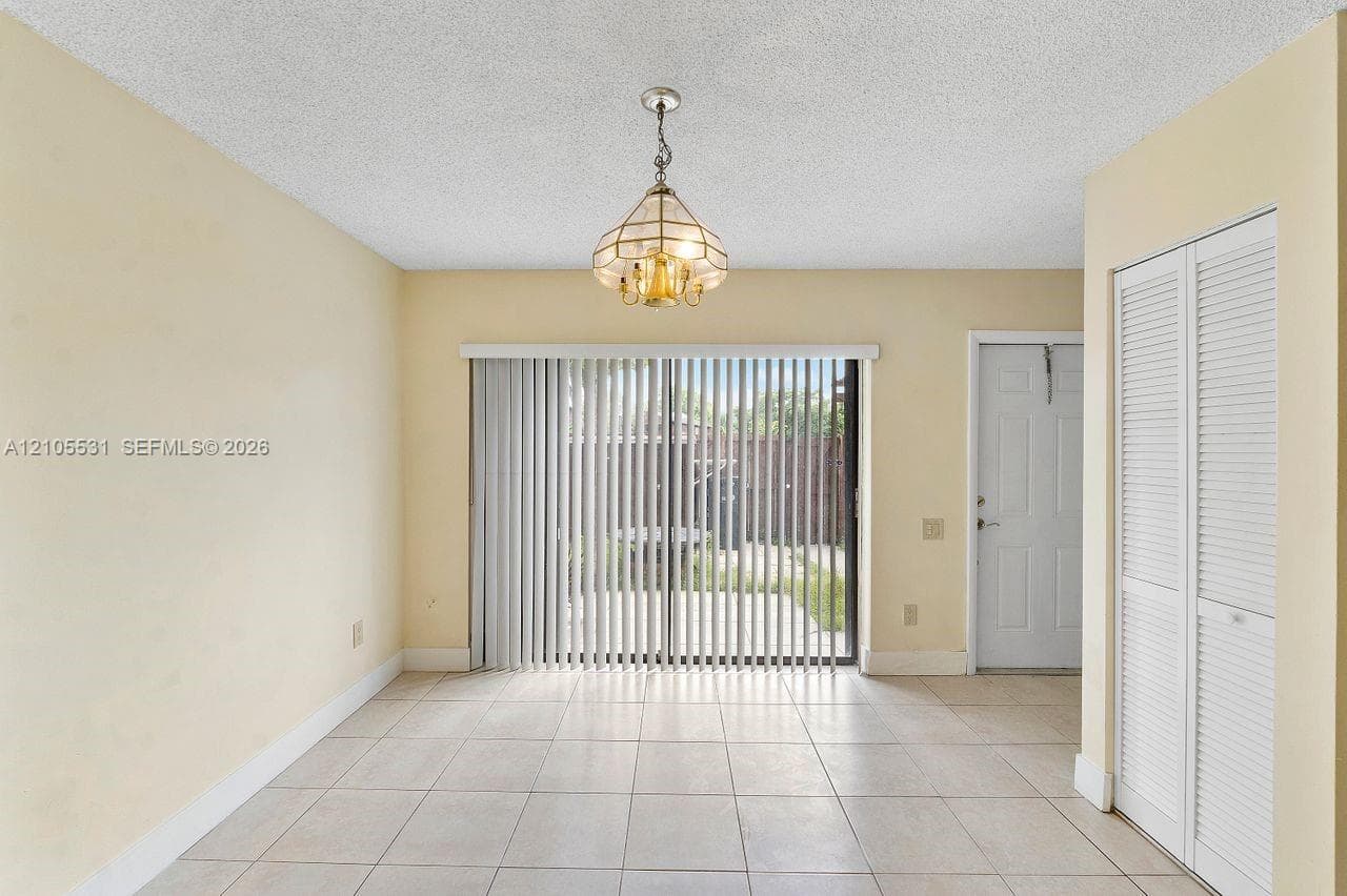 Tiled flooring with neutral wall paint and a textured ceiling