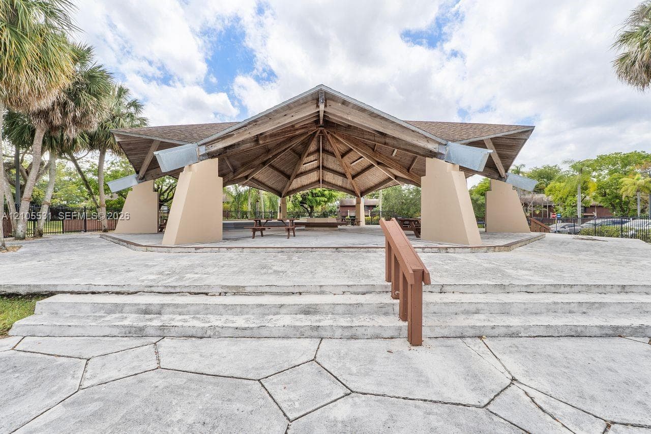 Open-air pavilion featuring an exposed wood beam ceiling and a concrete platform
