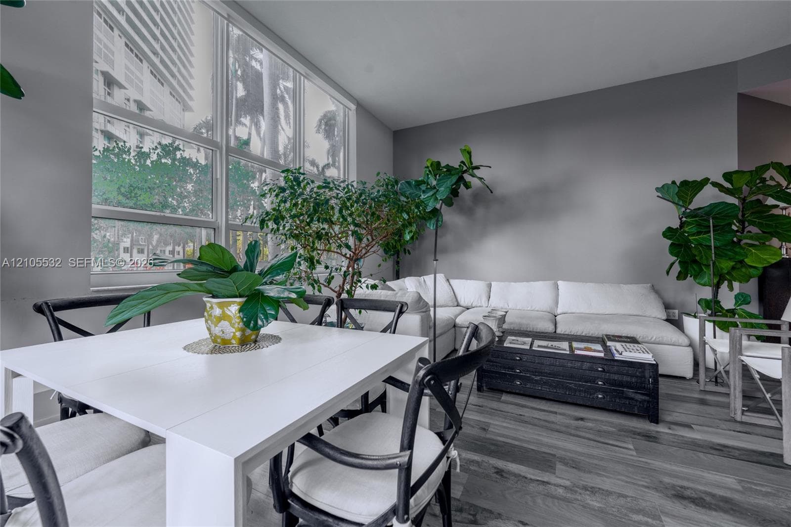 Floor-to-ceiling windows, wood-finish flooring, and neutral wall tones
