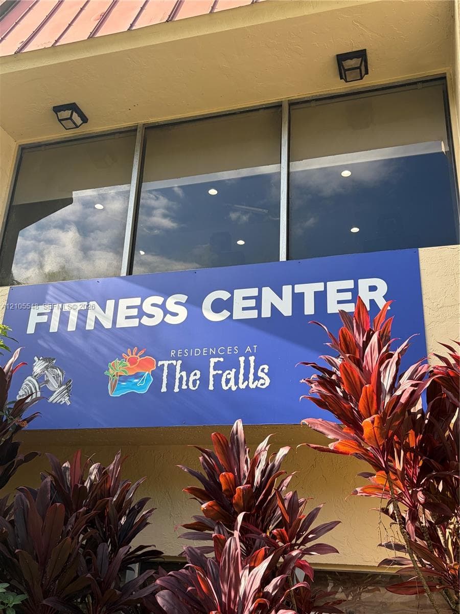 Gym featuring rubber flooring, recessed ceiling lighting, beam-style architecture, wall-to-wall mirrors, and dual ceiling fans
