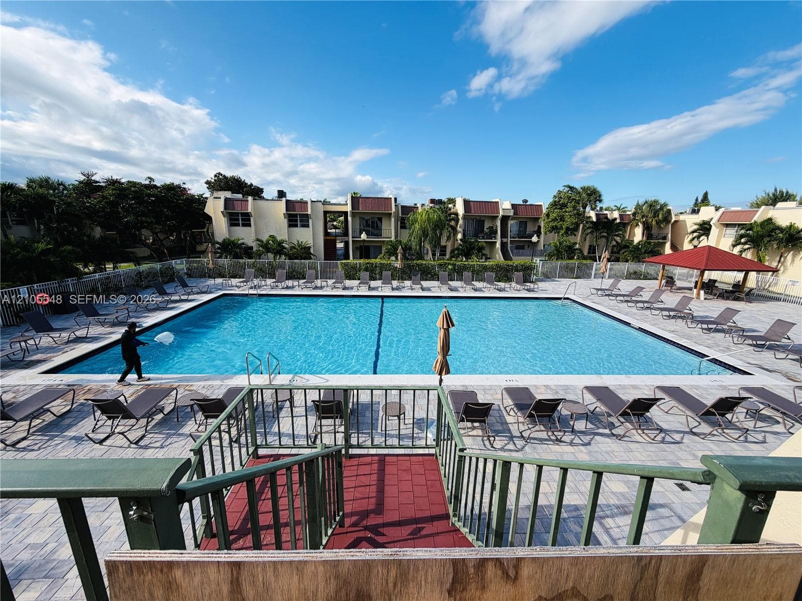 Large olympic size swimming pool with paved deck and perimeter fencing