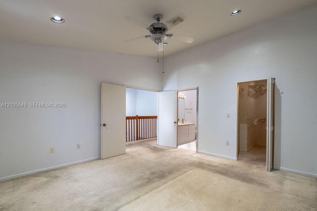 Vaulted ceiling featuring a ceiling fan, recessed lighting, and carpeted flooring