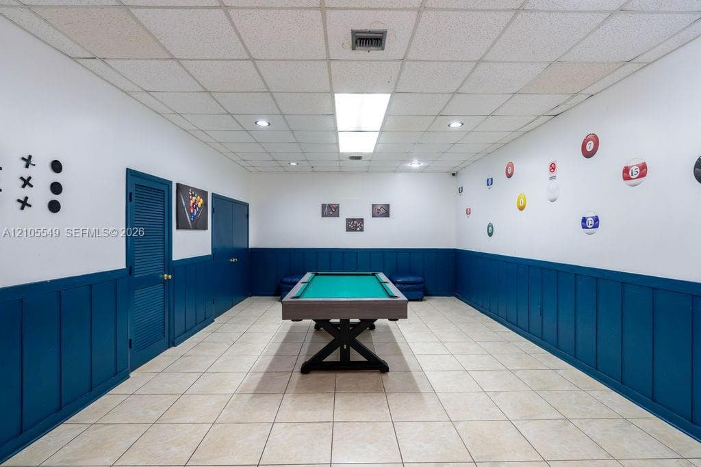 Tile flooring, recessed lighting, drop ceiling, wall paneling, and interior doors