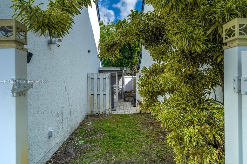 Gated entry leading to a paved patio area
