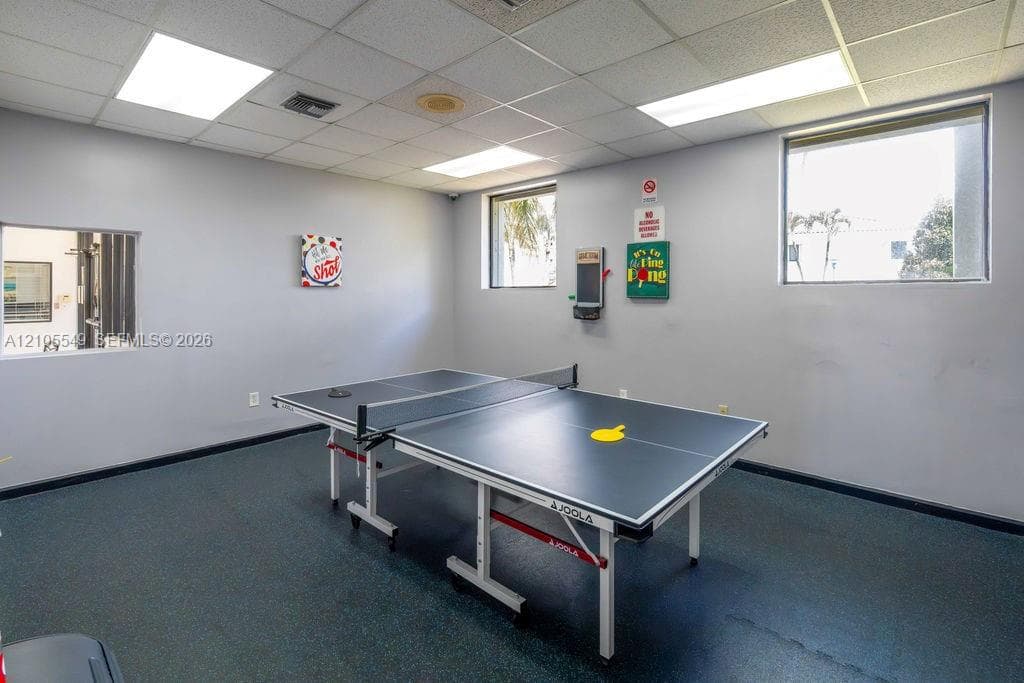 Recessed ceiling lights, acoustic ceiling tiles, two large windows, and resilient flooring