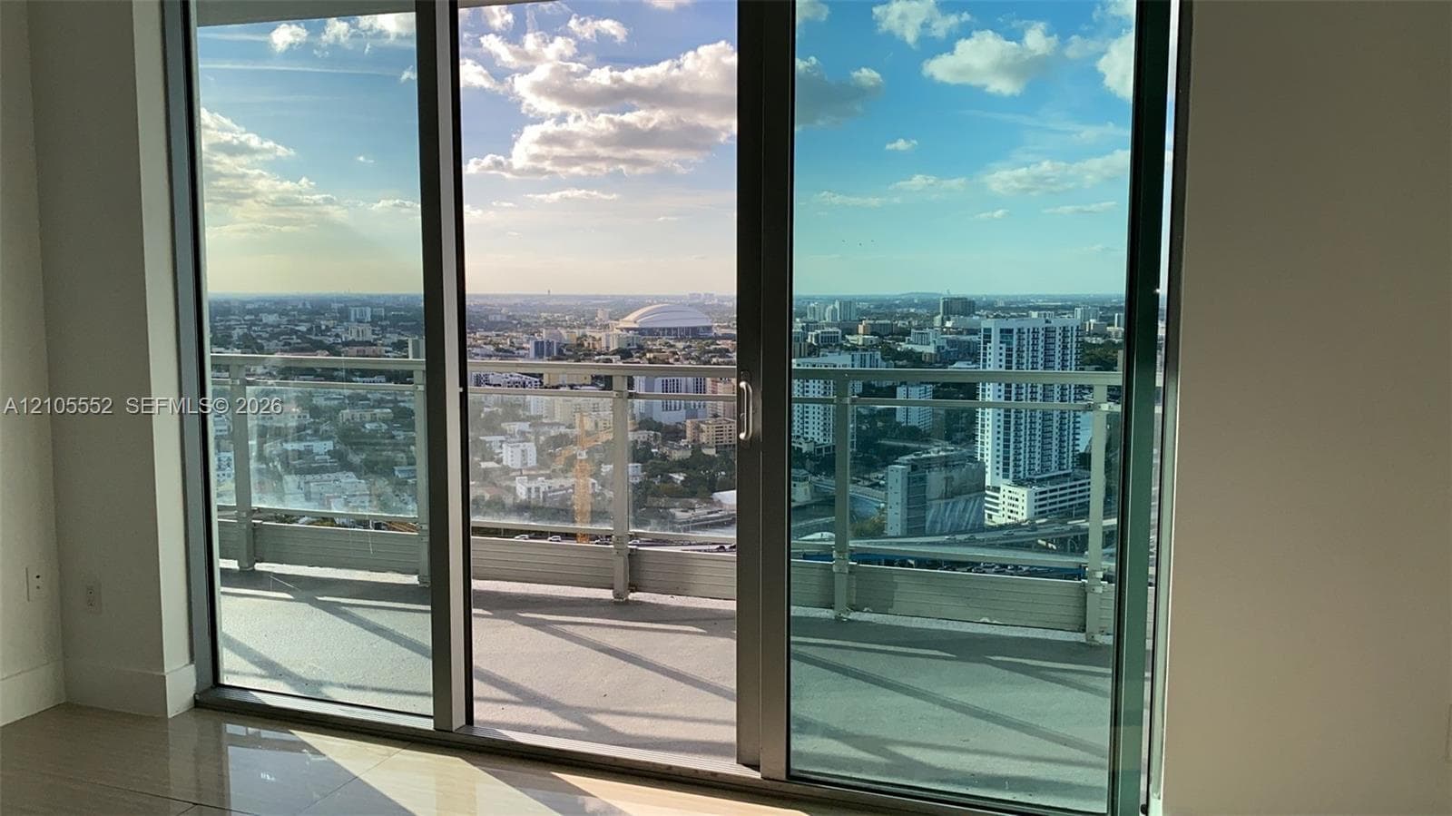 Sliding glass doors opening to a private balcony with glass and metal railings