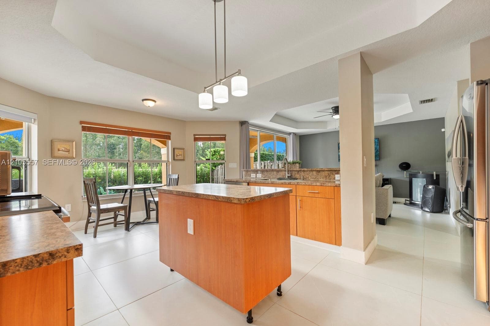 Kitchen featuring a portable island, light-toned cabinetry, and stone-finish countertops