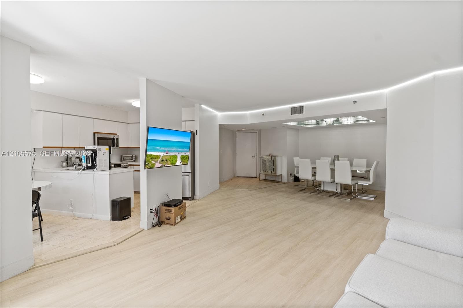 Spacious living room featuring an open-concept kitchen and direct access to a private balcony, creating a bright and inviting living space at Mystic Pointe in Aventura.