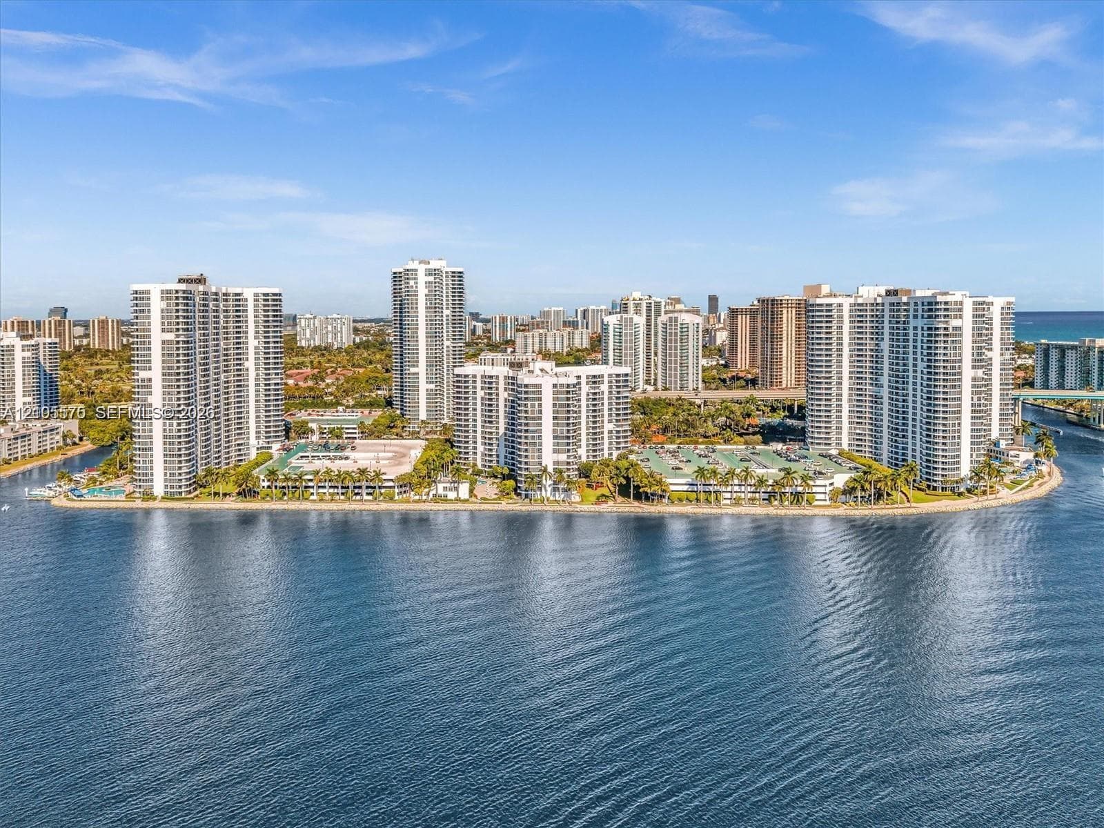 Waterfront high-rise community featuring multiple residential towers, extensive landscaping, and direct water access