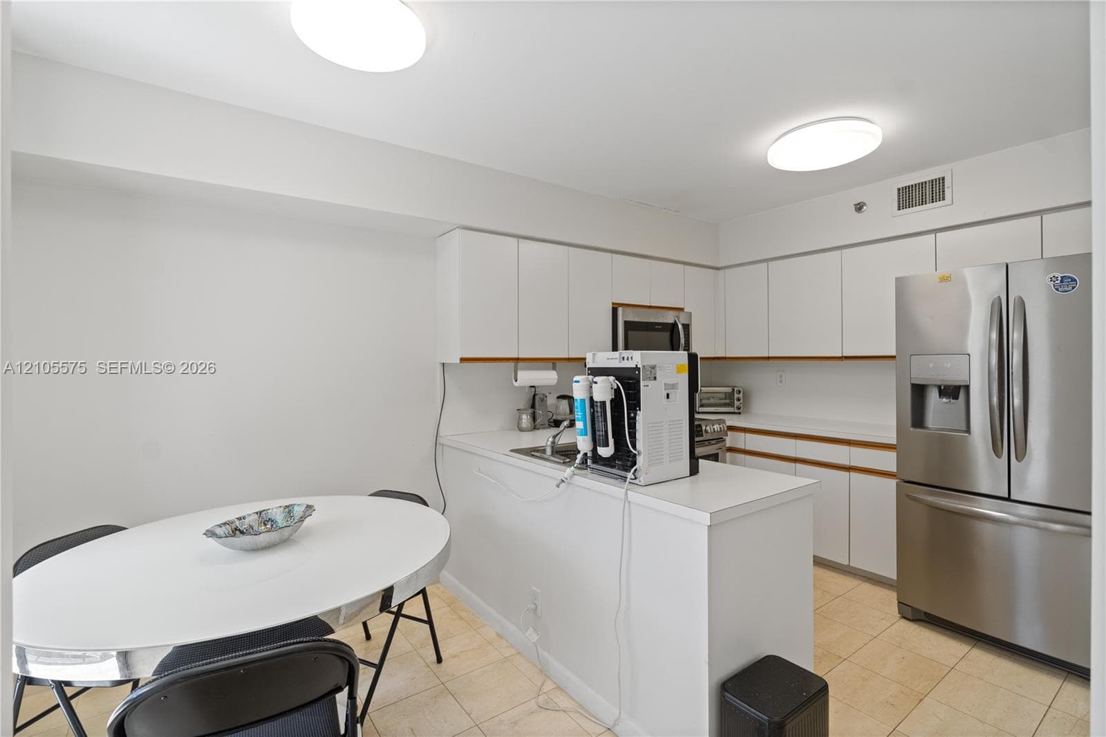Functional kitchen featuring a convenient breakfast area and direct balcony access, offering a comfortable setting for everyday dining at Mystic Pointe in Aventura.