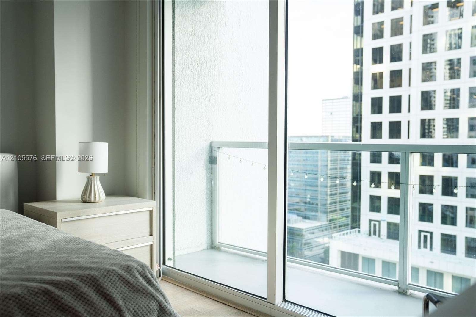 Floor-to-ceiling glass sliding doors opening to a private balcony with glass panel railings