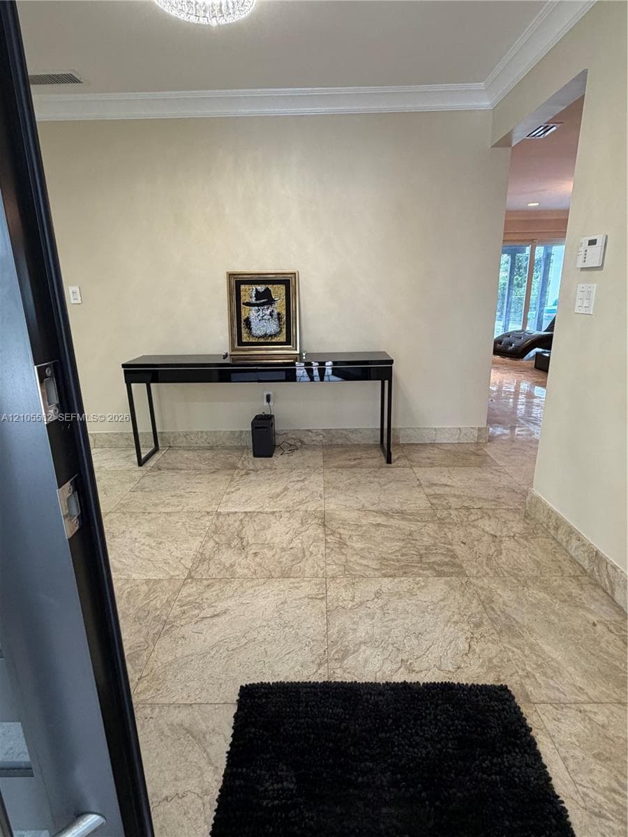 Recessed lighting, crown molding, and large-format tile flooring