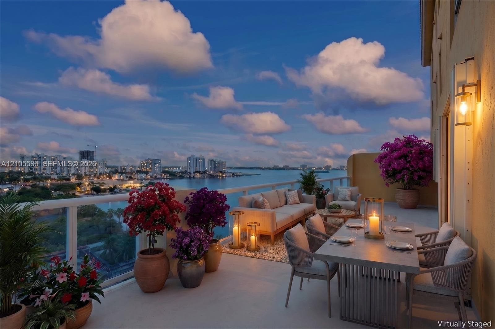 Expansive outdoor terrace featuring a glass railing, concrete-style flooring, and an exterior wall lantern
