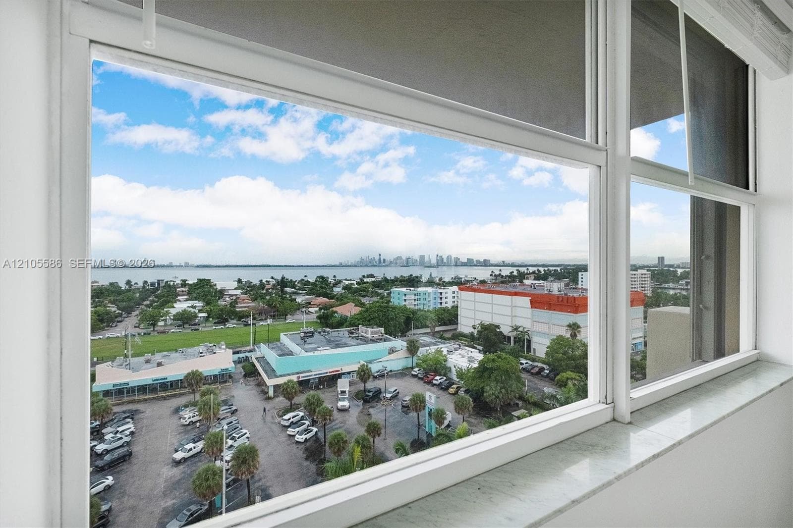 Expansive window framing a water body and a distant city skyline