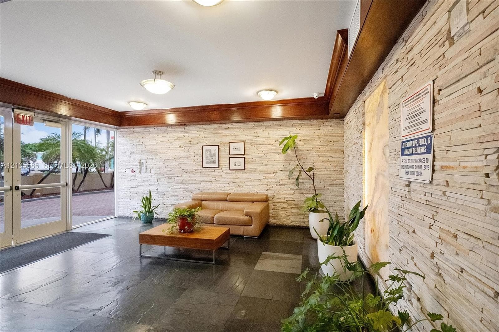 Lobby featuring stone-clad walls, dark tile flooring, and recessed lighting