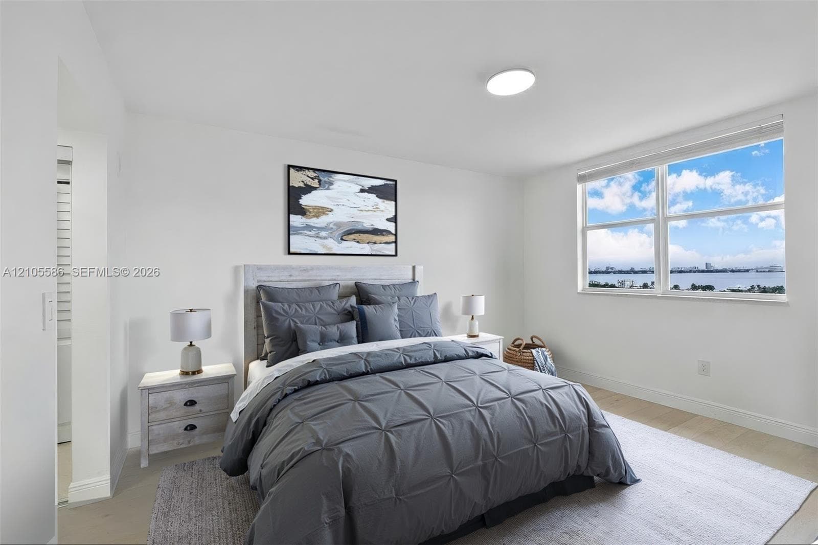 Large window with water scenery, recessed ceiling light, and light wood-finish flooring