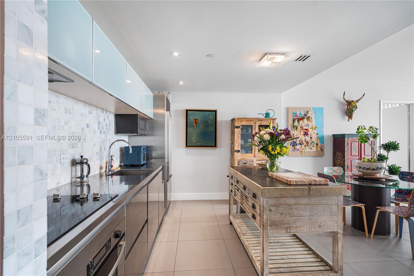 Sleek kitchen featuring a stainless steel appliance suite, mosaic tile backsplash, modern cabinetry, and recessed lighting