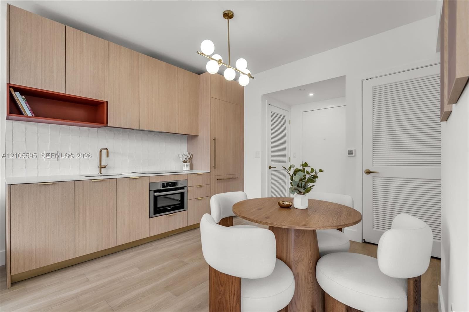 Custom wood-finish cabinetry featuring an open display shelf, white stone countertops, a multi-globe pendant light fixture, and wood-finish flooring