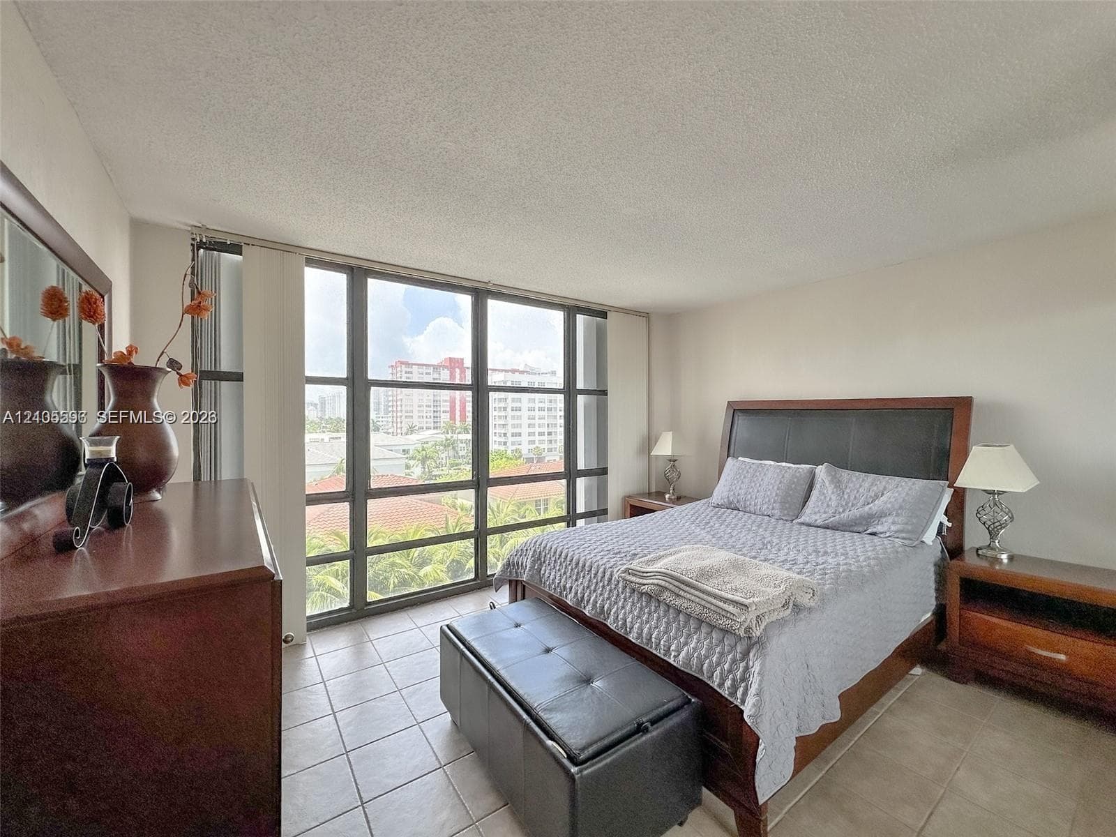 Floor-to-ceiling windows with dark metal framing and large-format tile flooring