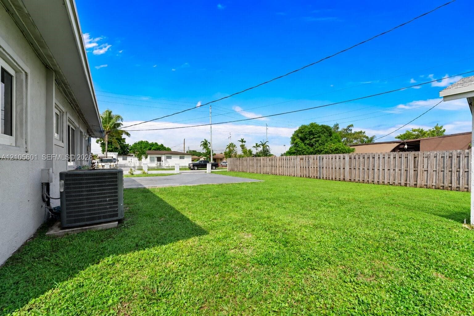 Expansive grassy yard with a wood fence perimeter