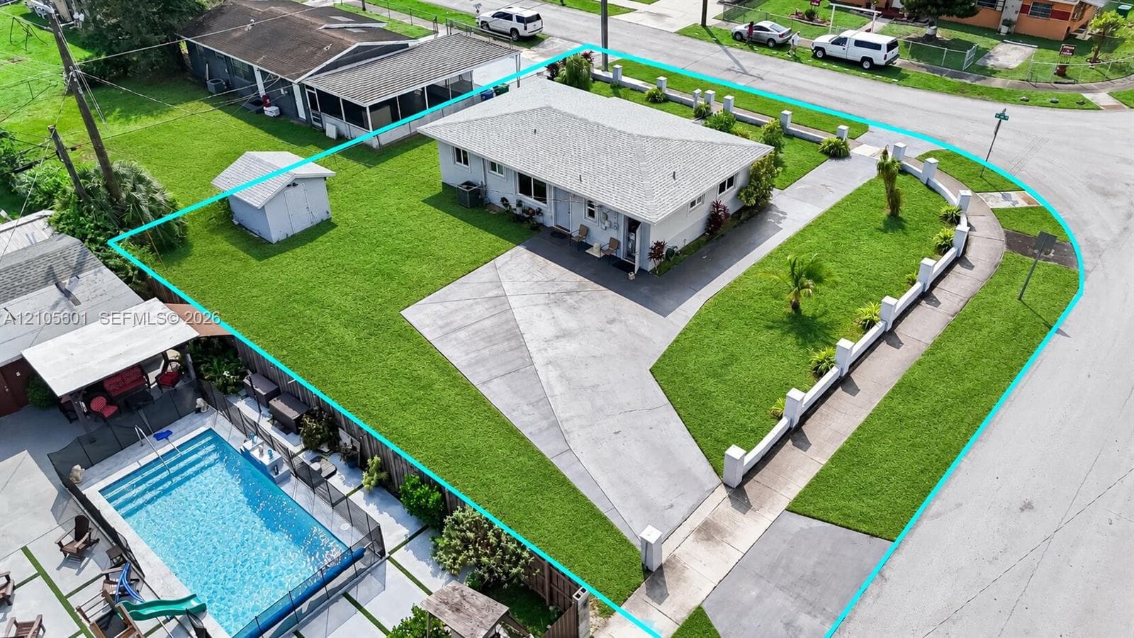 Single-story residence with a concrete driveway, a front lawn with landscaping, and a fenced backyard featuring a swimming pool