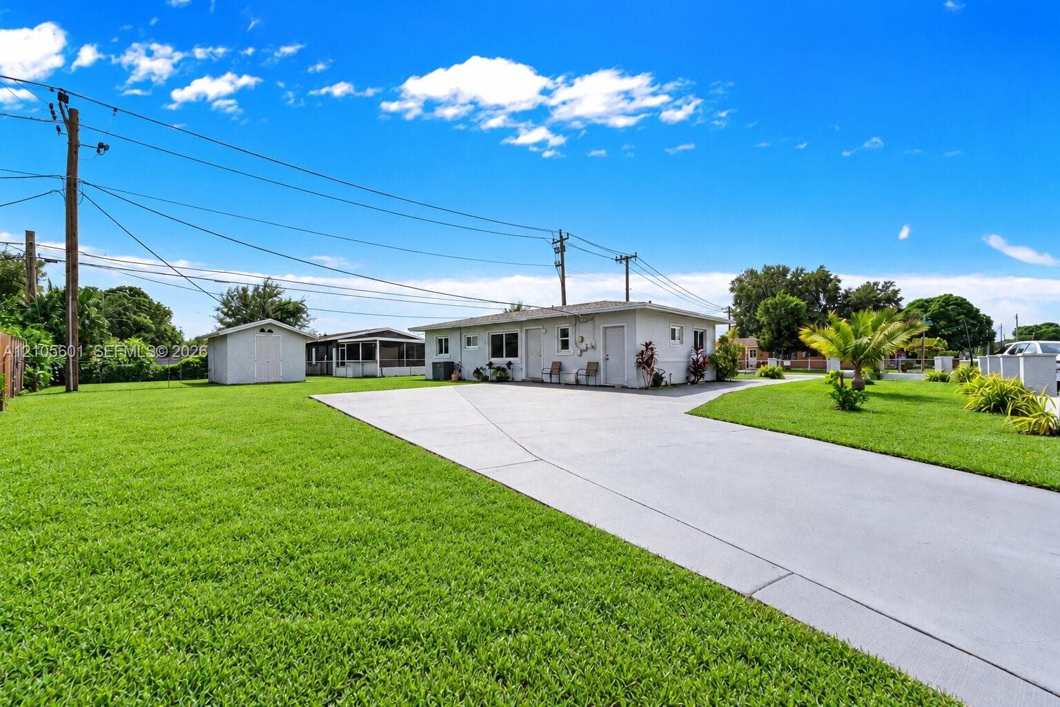 Expansive grass lawn, detached storage shed, paved driveway, and mature landscaping