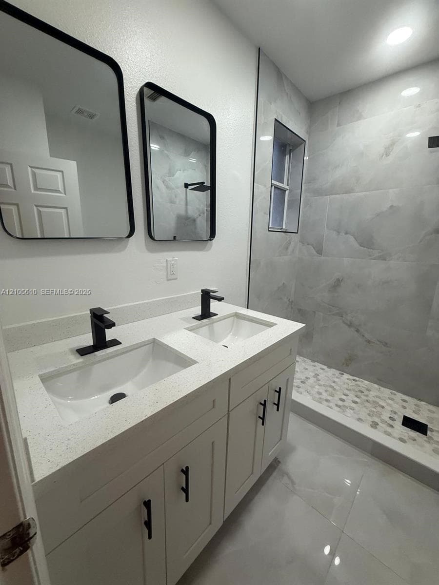 Dual-sink vanity with a solid-surface countertop, rectangular undermount sinks, matte black faucets, and coordinating hardware
