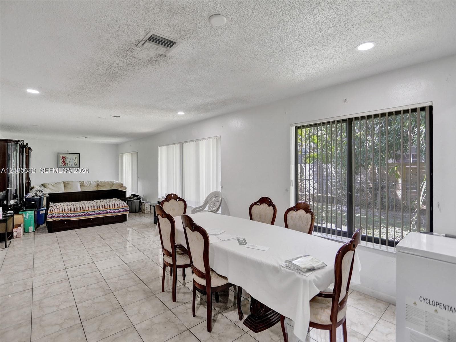 Living area featuring large format ceramic tile flooring, recessed lighting, and expansive sliding glass doors providing natural light