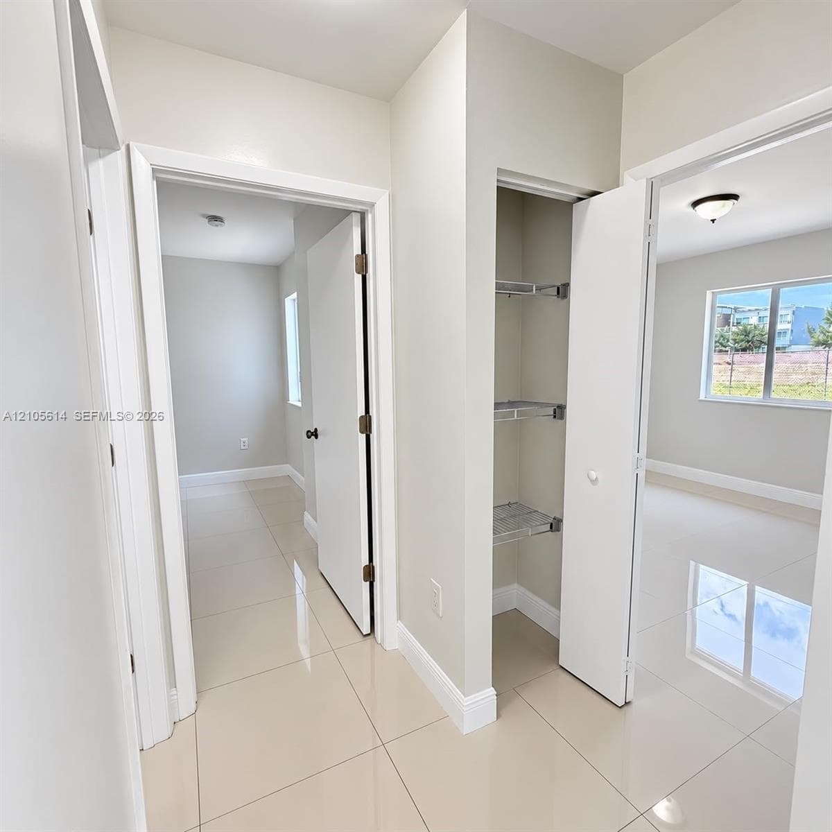 Polished large-format tile flooring, built-in wire shelving storage, and neutral wall tones