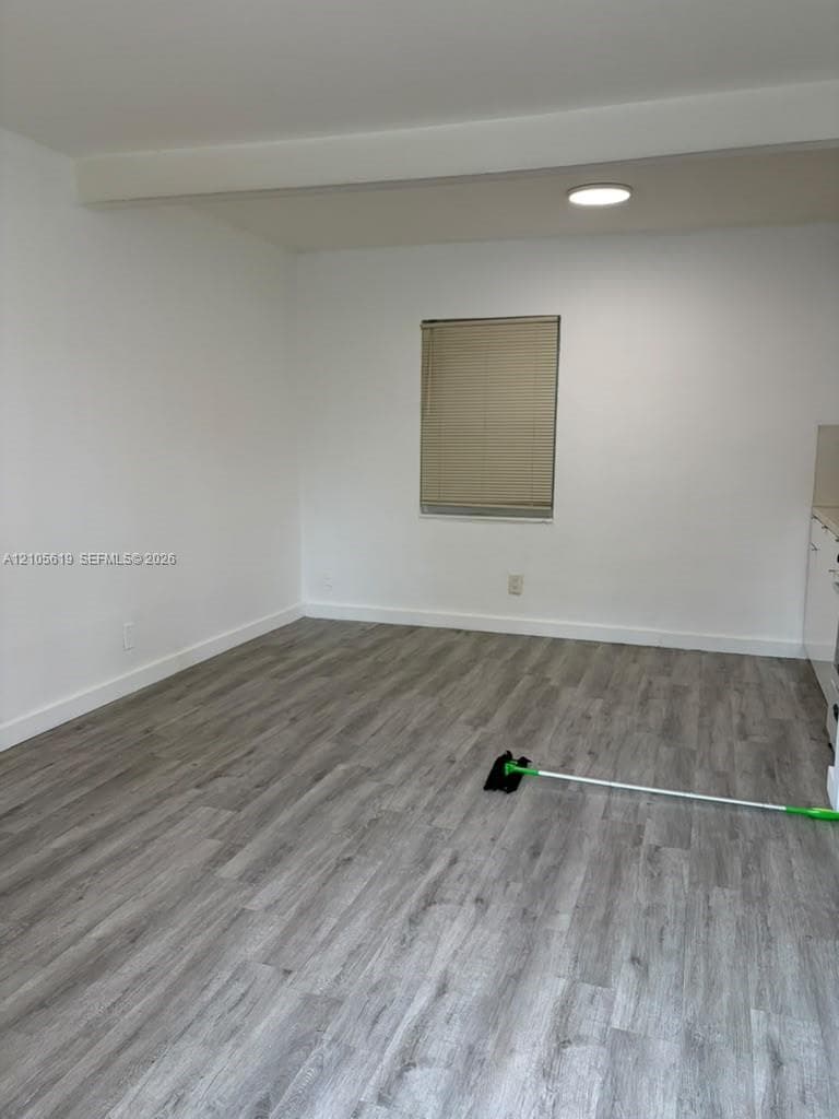 Wood-finish flooring, recessed ceiling lighting, and a single-pane window with installed blinds
