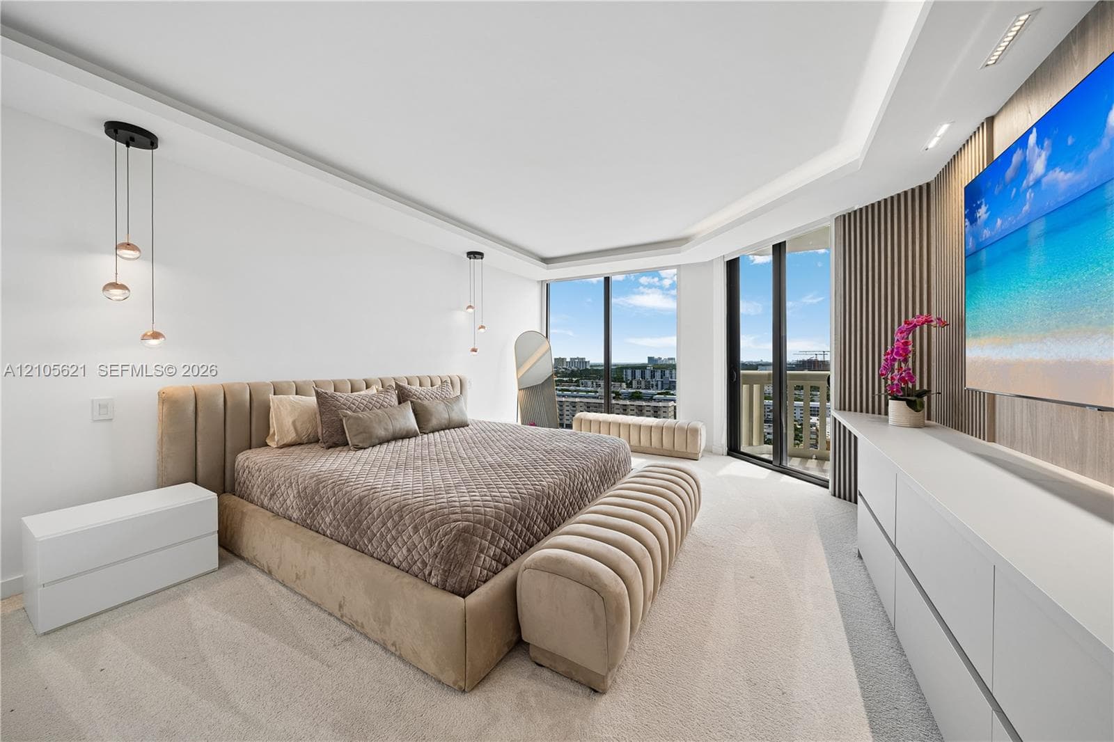 Floor-to-ceiling windows, recessed tray ceiling, custom wood-slat accent wall, built-in cabinetry, and multi-tier pendant lighting