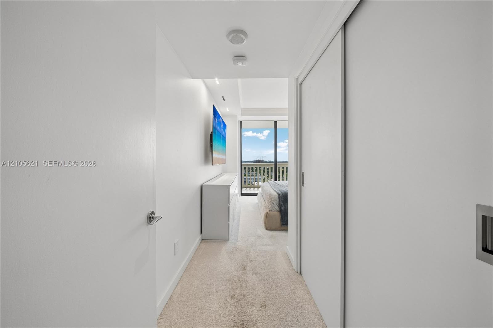 Hallway featuring recessed ceiling lighting, wall-to-wall carpeting, and floor-to-ceiling sliding closet doors