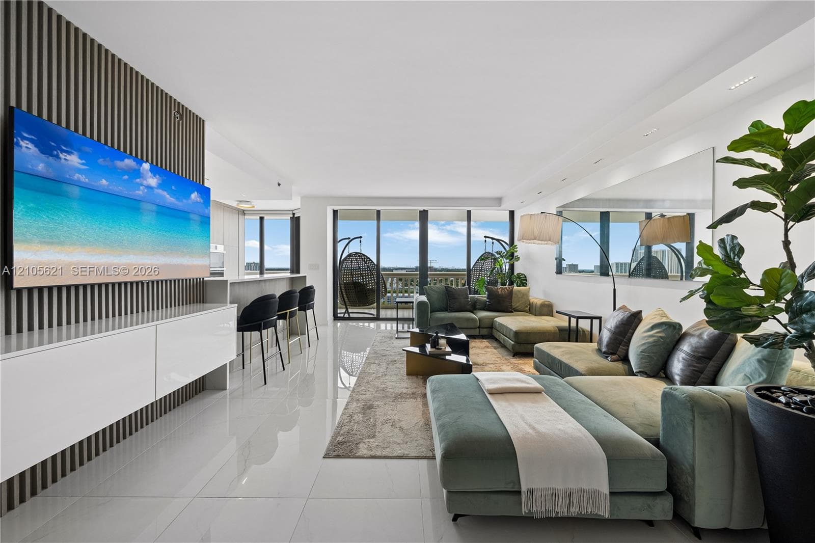 Living area featuring large-format tile flooring, vertical slat wall paneling, built-in white cabinetry, recessed ceiling lighting, and floor-to-ceiling glass sliding doors